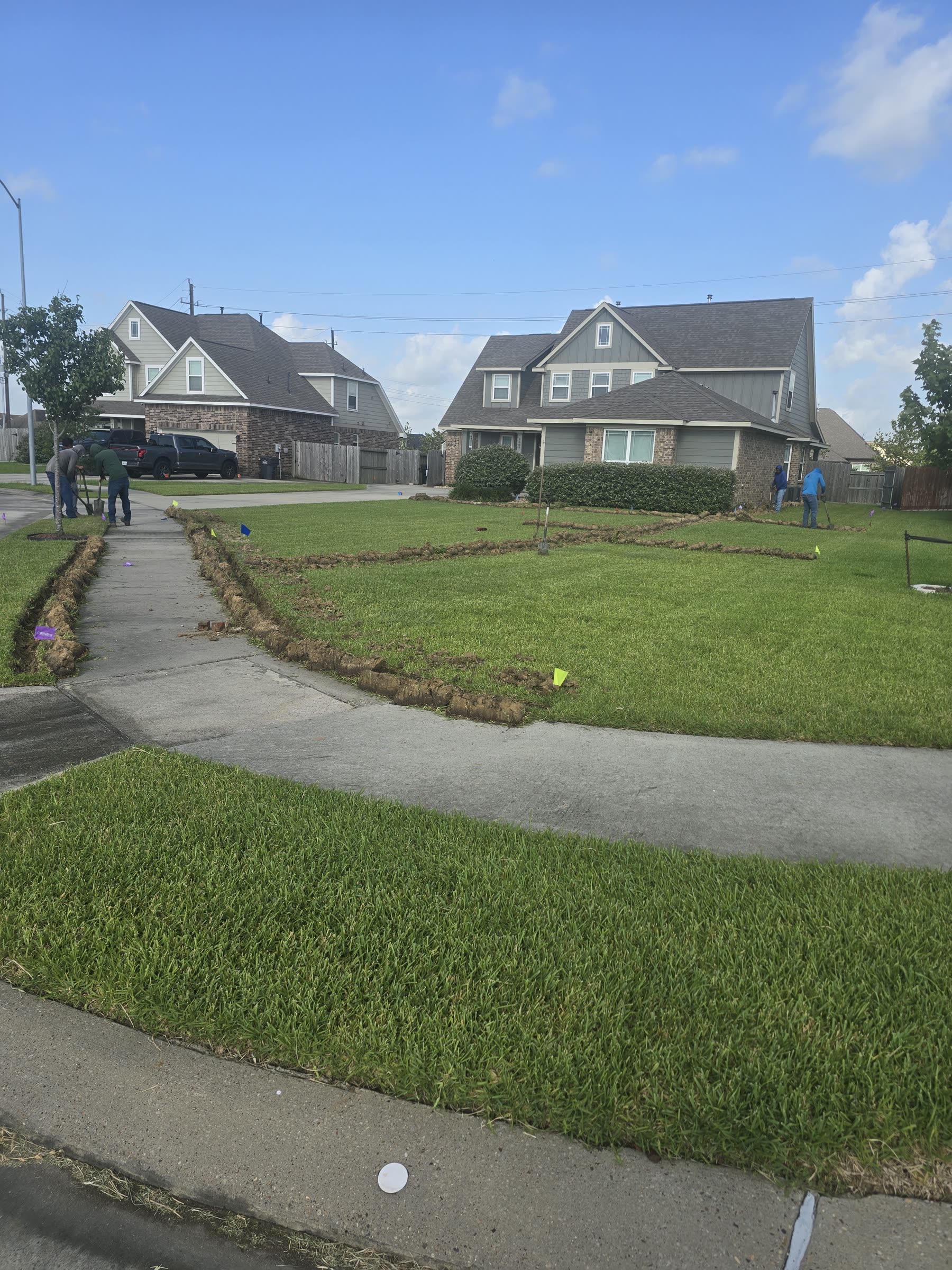 Sprinkler installation crew trenching lawn in Greater Houston